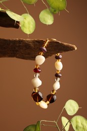 Photo of Stylish presentation of beautiful bracelet with gemstones on brown background