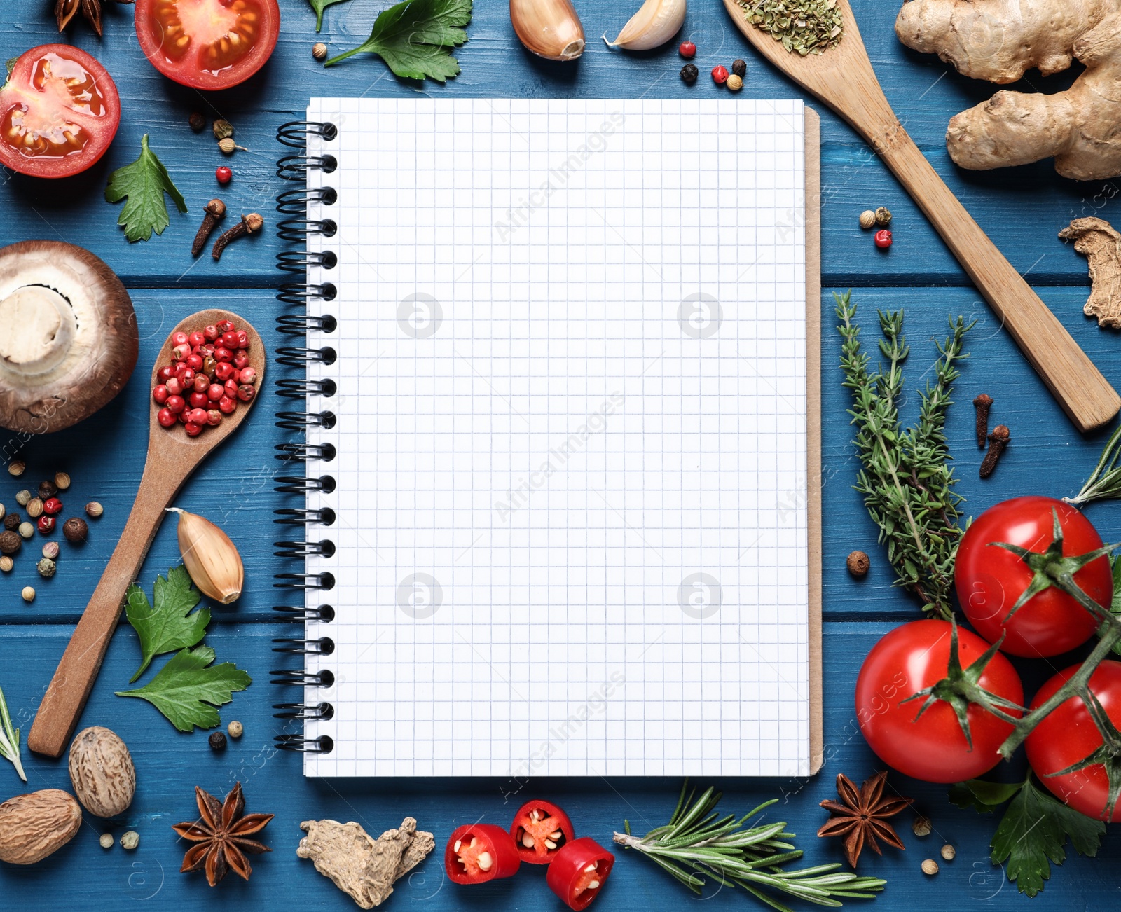 Photo of Open recipe book and different ingredients on light blue wooden table, flat lay. Space for text