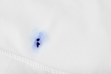 Photo of Stain of blue ink on white shirt, top view. Space for text