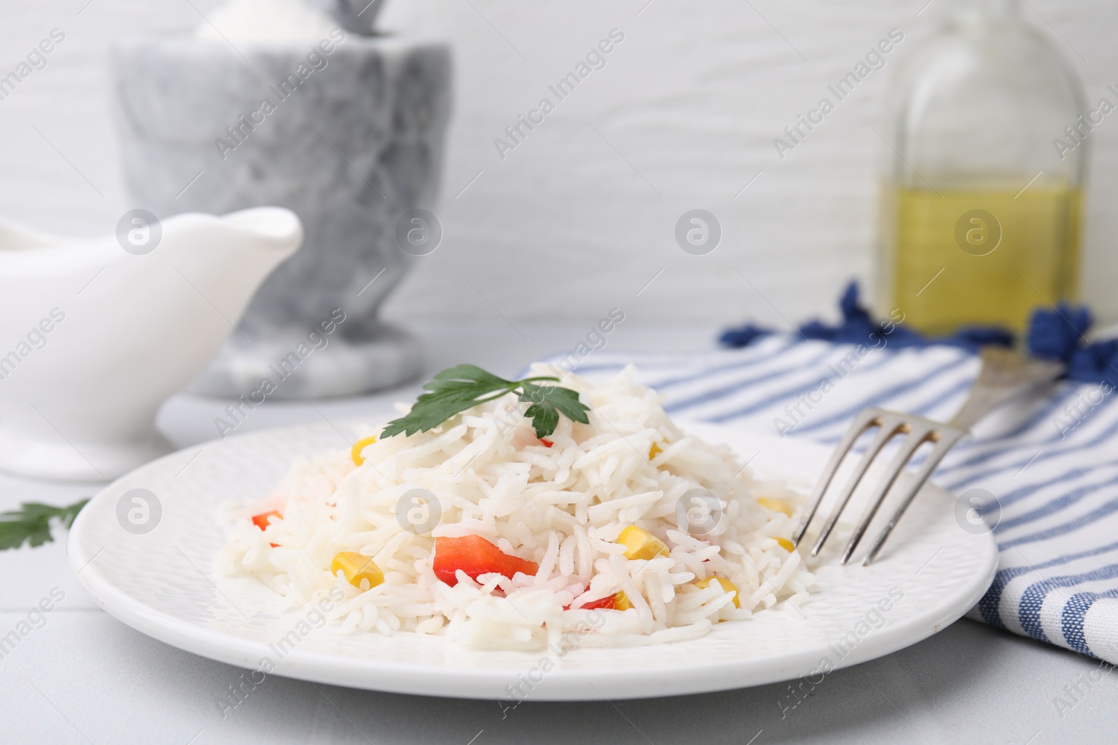 Photo of Delicious rice with vegetables and parsley served on table, closeup