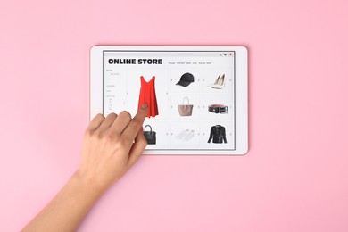 Photo of Woman with tablet shopping online on pink background, top view