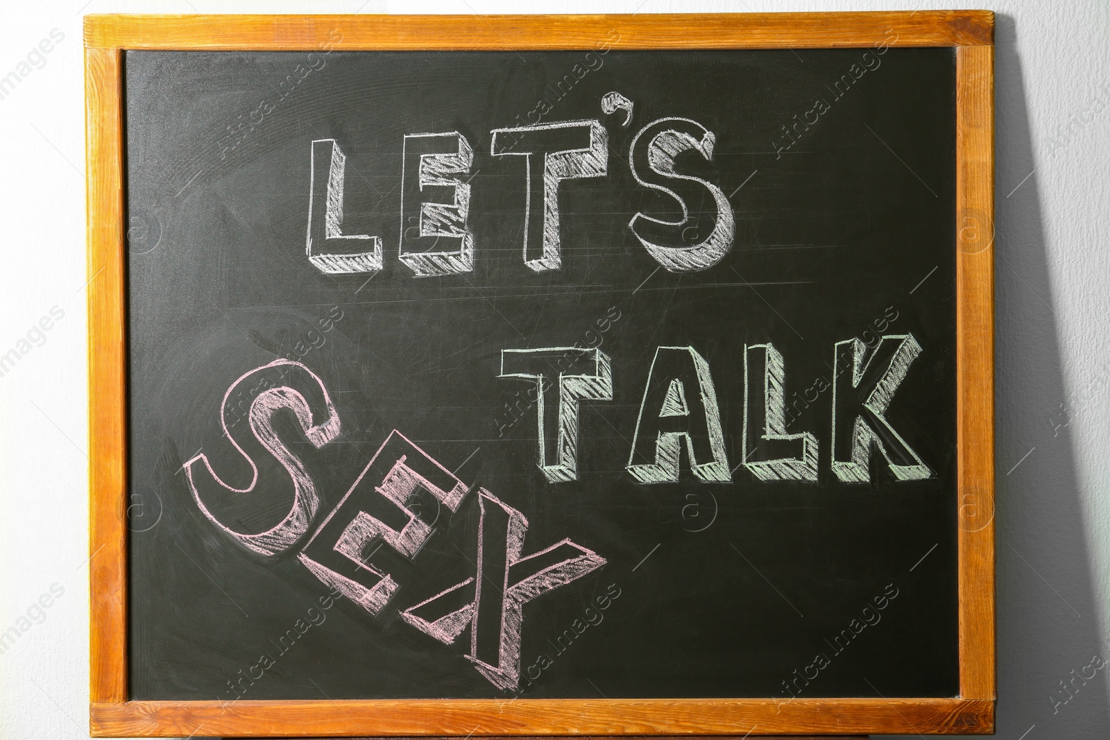 Photo of Small blackboard with written phrase "LET'S TALK SEX". School education