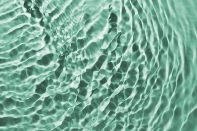 Image of Rippled surface of clear water on green background, closeup