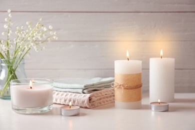 Photo of Beautiful composition with burning wax candles on table