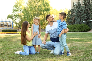 Photo of Happy family with children spending time together in green park on sunny day