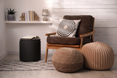 Photo of Stylish comfortable poufs near armchair in room. Home design