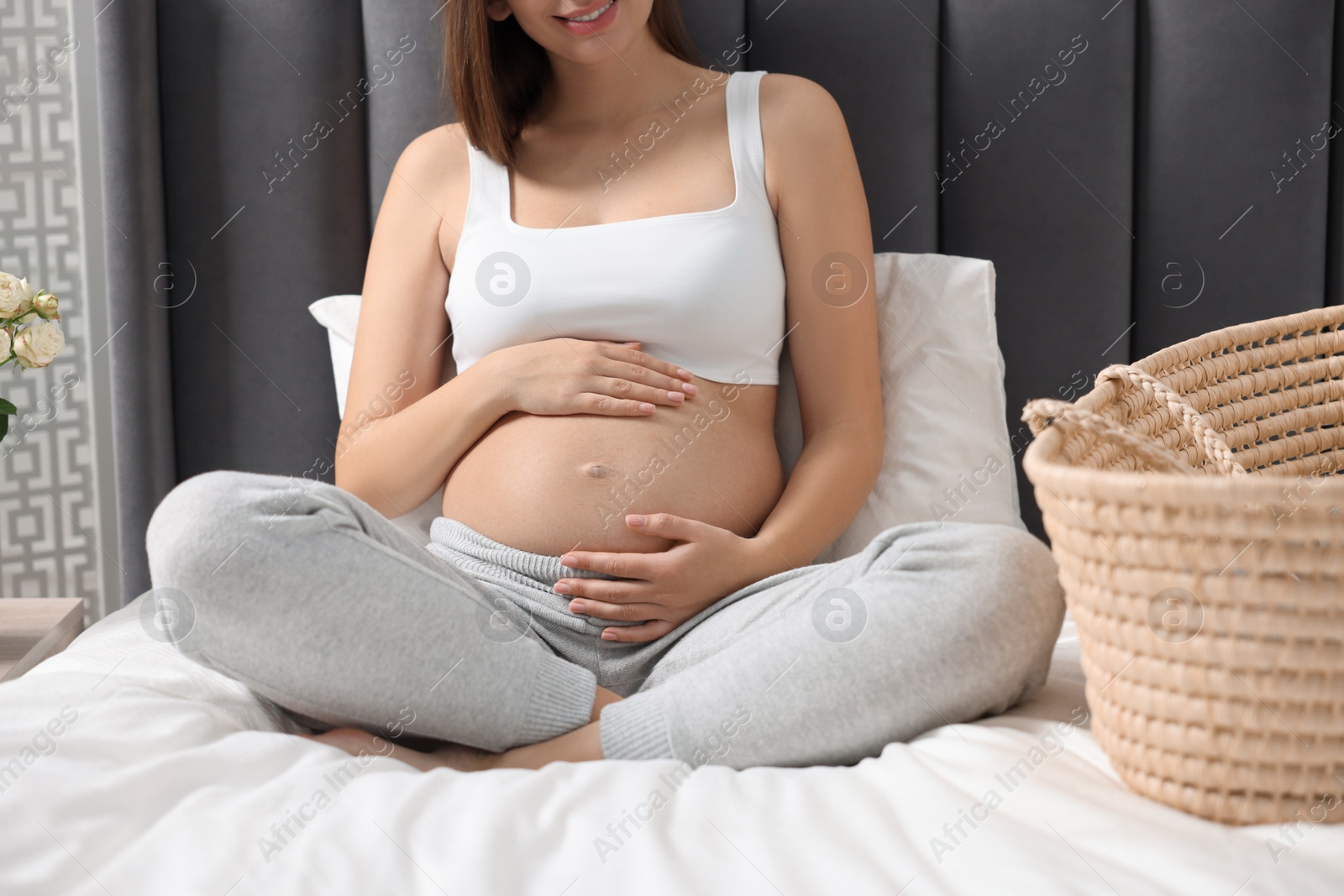 Photo of Pregnant woman on bed indoors, closeup view