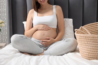 Photo of Pregnant woman on bed indoors, closeup view