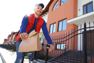 Male courier on bicycle delivering food in city