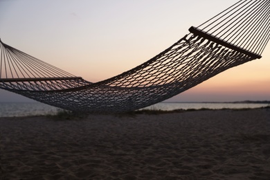 Photo of Empty hammock on beach at sunset. Time to relax