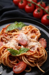 Tasty pasta with tomato sauce, cheese and basil on table, closeup