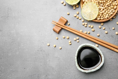 Flat lay composition with soy sauce and beans on grey table. Space for text