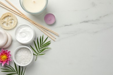 Flat lay composition with different spa products on white marble table. Space for text