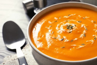 Delicious pumpkin cream soup in bowl on table, closeup