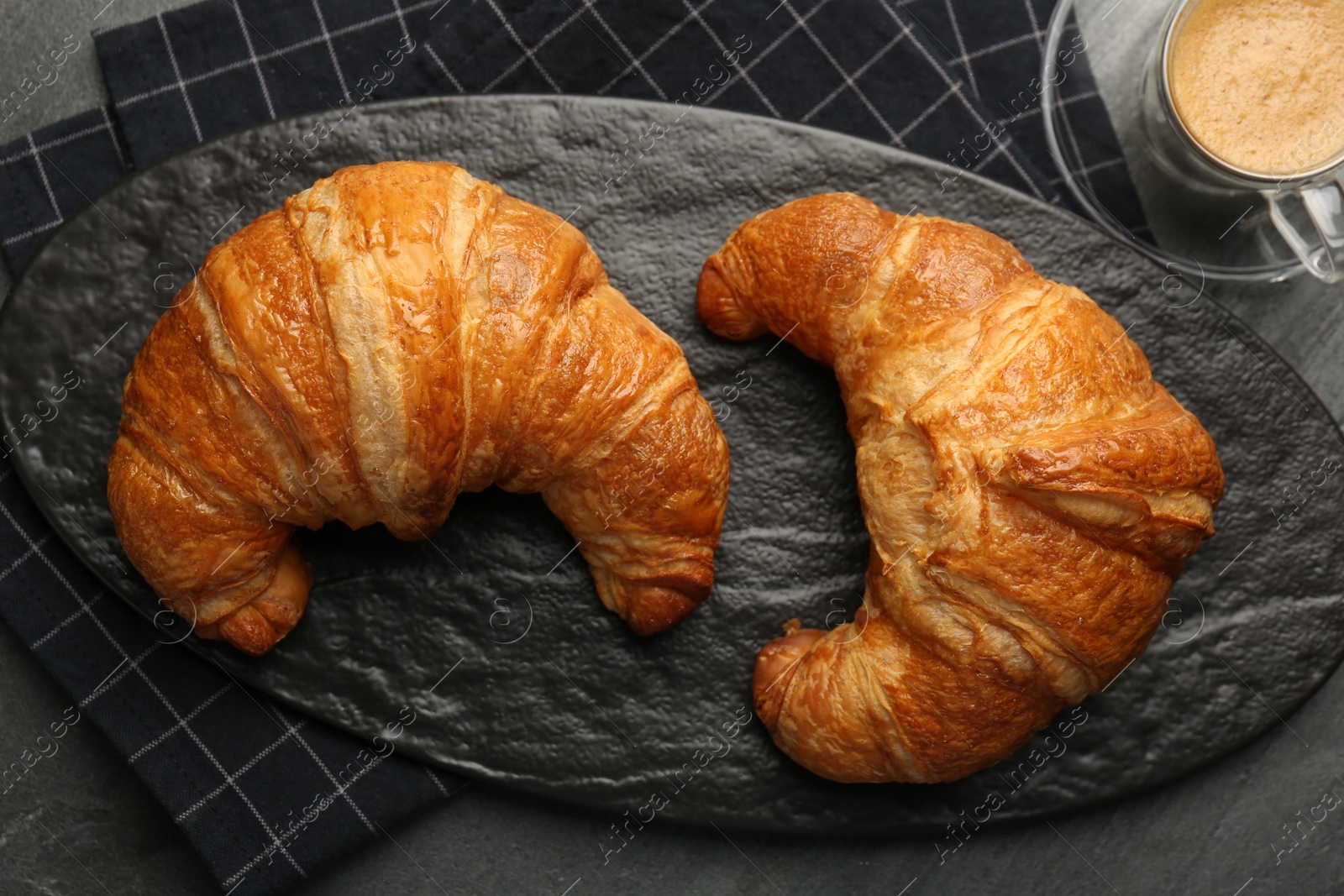 Photo of Delicious fresh croissants and cup of coffee on table, flat lay