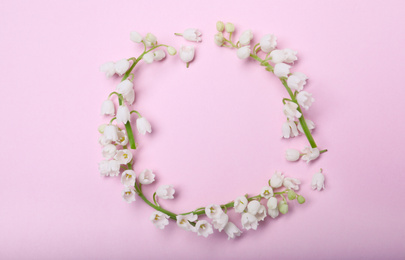 Frame made with lily of the valley flowers on pink background, flat lay. Space for text