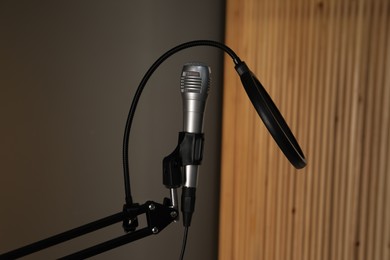 Photo of Stand with microphone and pop filter indoors. Sound recording and reinforcement