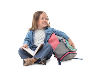 Cute little girl with book and backpack on white background