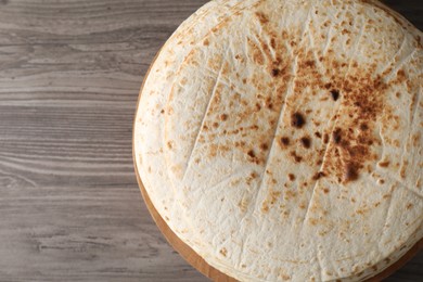 Photo of Many tasty homemade tortillas on wooden table, top view. Space for text