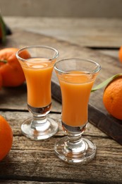 Delicious tangerine liqueur and fresh fruits on wooden table