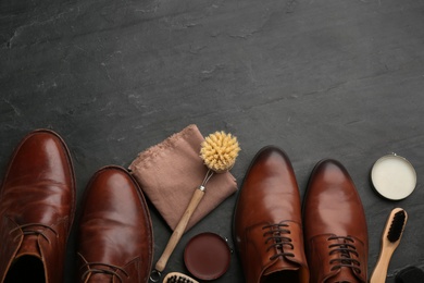 Flat lay composition with shoe care accessories and footwear on black background. Space for text