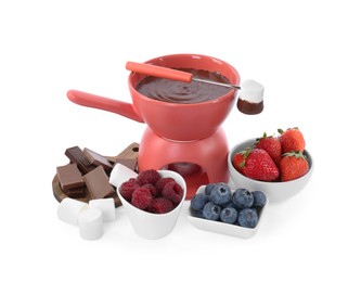 Photo of Fondue pot with melted chocolate, fresh berries, marshmallows and fork isolated on white