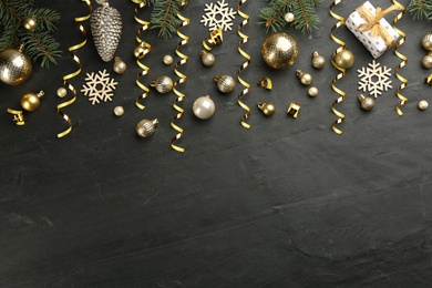 Photo of Flat lay composition with serpentine streamers and Christmas decor on black background. Space for text