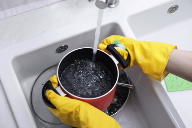 Photo of Woman washing dirty dishes in kitchen sink, closeup