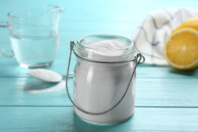 Photo of Baking soda in jar on blue wooden table