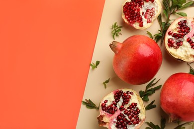 Photo of Flat lay composition with ripe pomegranates on color background. Space for text