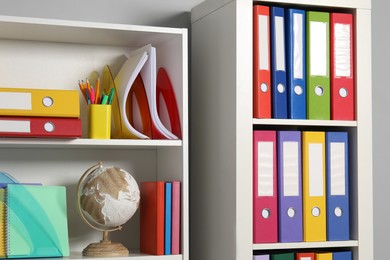 Photo of Colorful binder office folders and other stationery on shelving unit