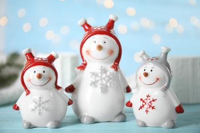 Photo of Three decorative snowmen on light blue table