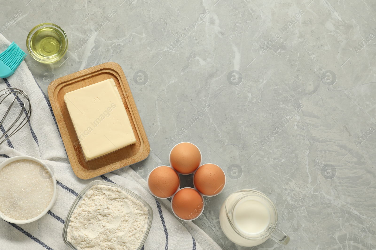 Photo of Flat lay composition with fresh butter and other products on grey marble table. Space for text