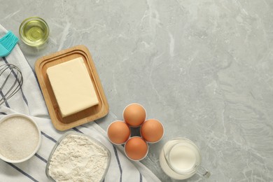 Photo of Flat lay composition with fresh butter and other products on grey marble table. Space for text