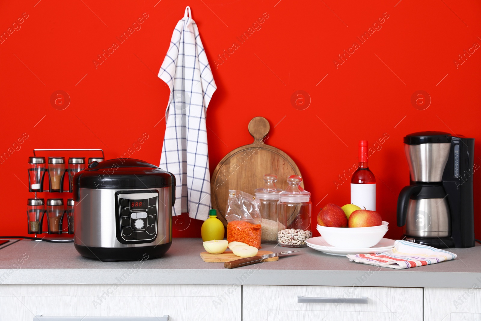Photo of New modern multi cooker, coffeemaker and products on table in kitchen