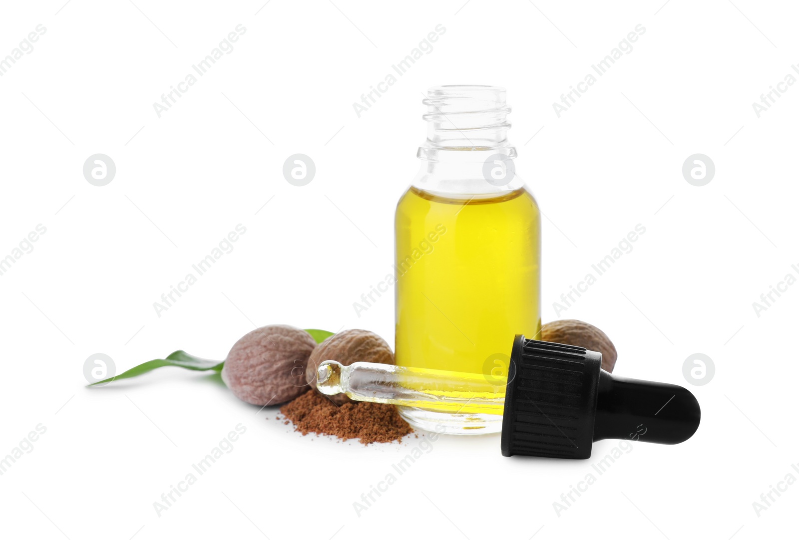 Photo of Bottle of nutmeg oil, pipette and nuts on white background