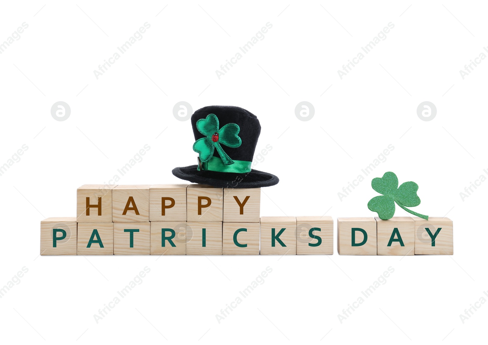 Photo of Leprechaun hat, clover leaves and wooden cubes with phrase SAINT PATRICK'S DAY on white background