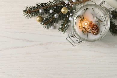 Photo of Burning scented conifer candle and Christmas decor on white wooden table, flat lay. Space for text