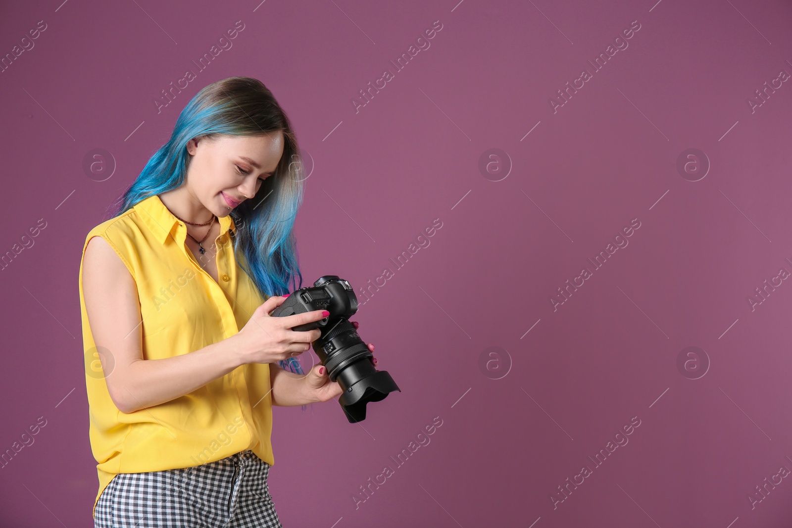 Photo of Young female photographer with camera on color background