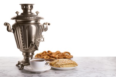 Photo of Vintage samovar, cup of hot drink and snacks on marble table against white background, space for text. Traditional Russian tea ceremony