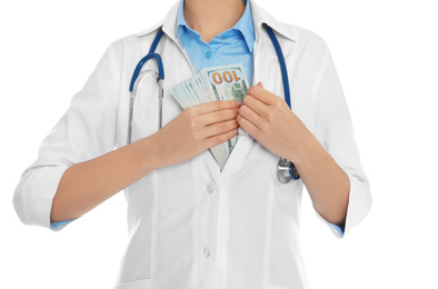 Photo of Doctor putting bribe into pocket on white background, closeup. Corruption in medicine
