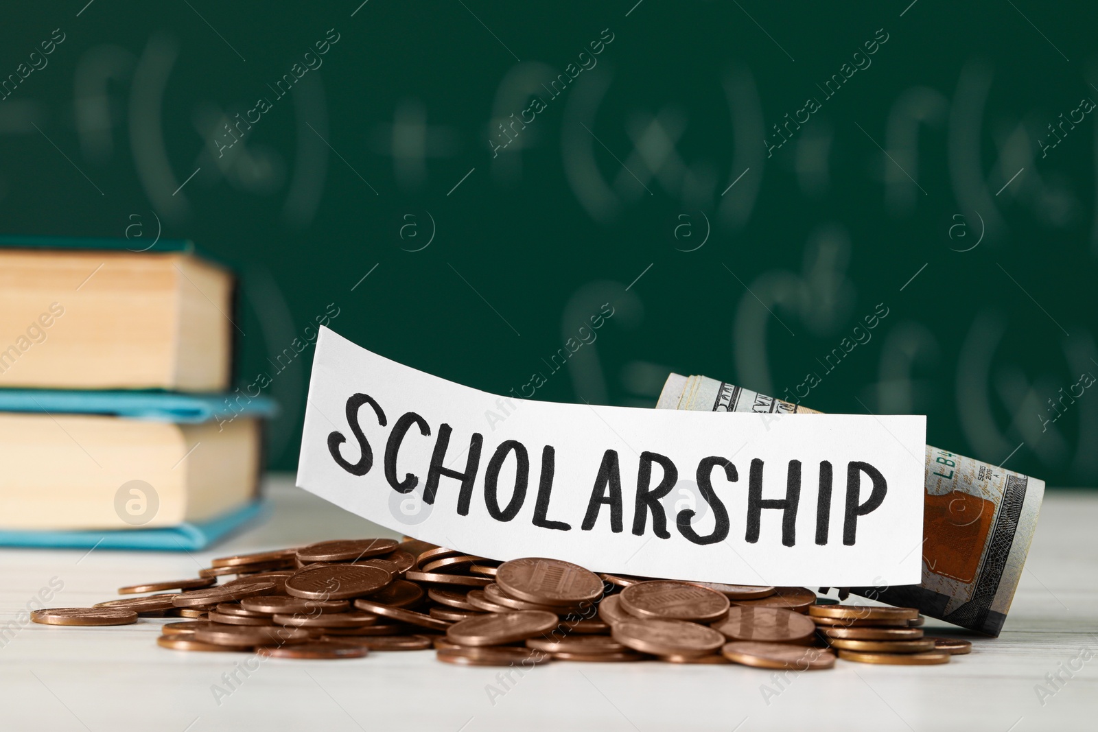 Photo of Sheet of paper with word Scholarship, coins and dollar banknotes on white wooden table