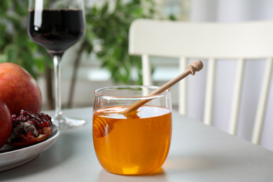 Photo of Jar with honey on grey table. Rosh Hashanah holiday