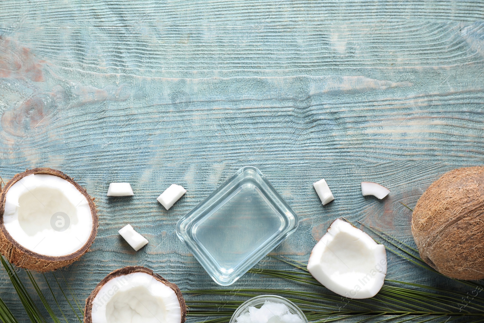 Photo of Flat lay composition with coconut oil on light blue wooden table, space for text