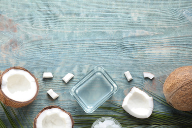Photo of Flat lay composition with coconut oil on light blue wooden table, space for text