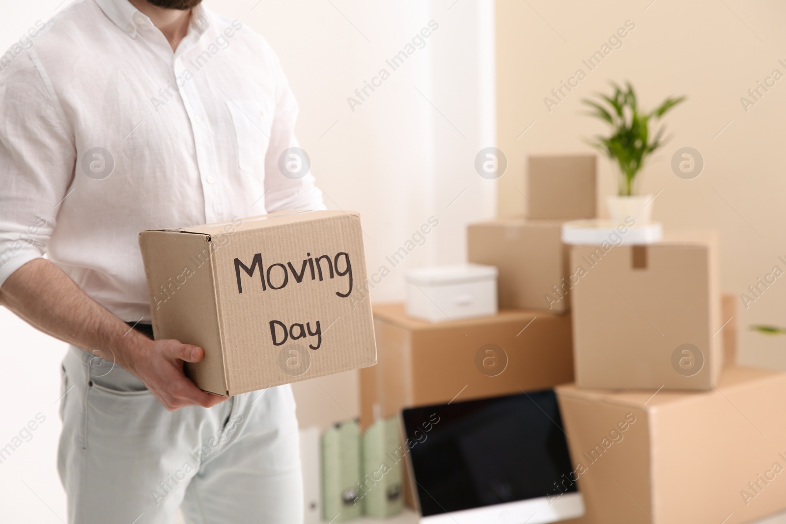 Photo of Man holding moving box in new office, closeup. Space for text