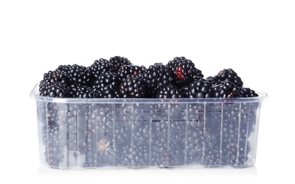 Photo of Plastic container with blackberries on white background