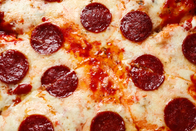 Photo of Hot delicious pepperoni pizza with melted cheese, closeup