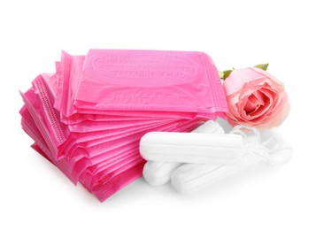 Photo of Tampons, disposable menstrual pads and beautiful rose on white background