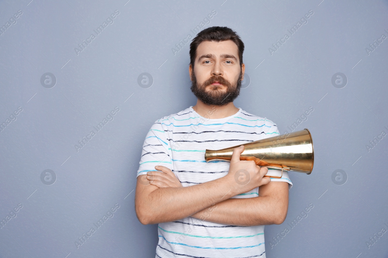 Photo of Young man with megaphone on grey background